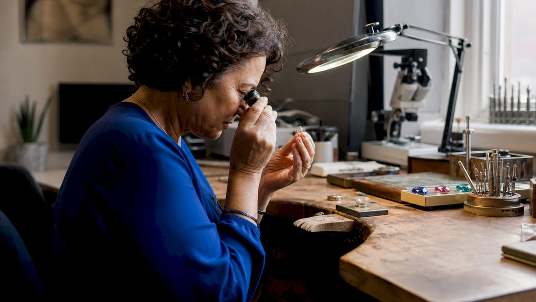 Jeweller examining diamond ring closely with loupe