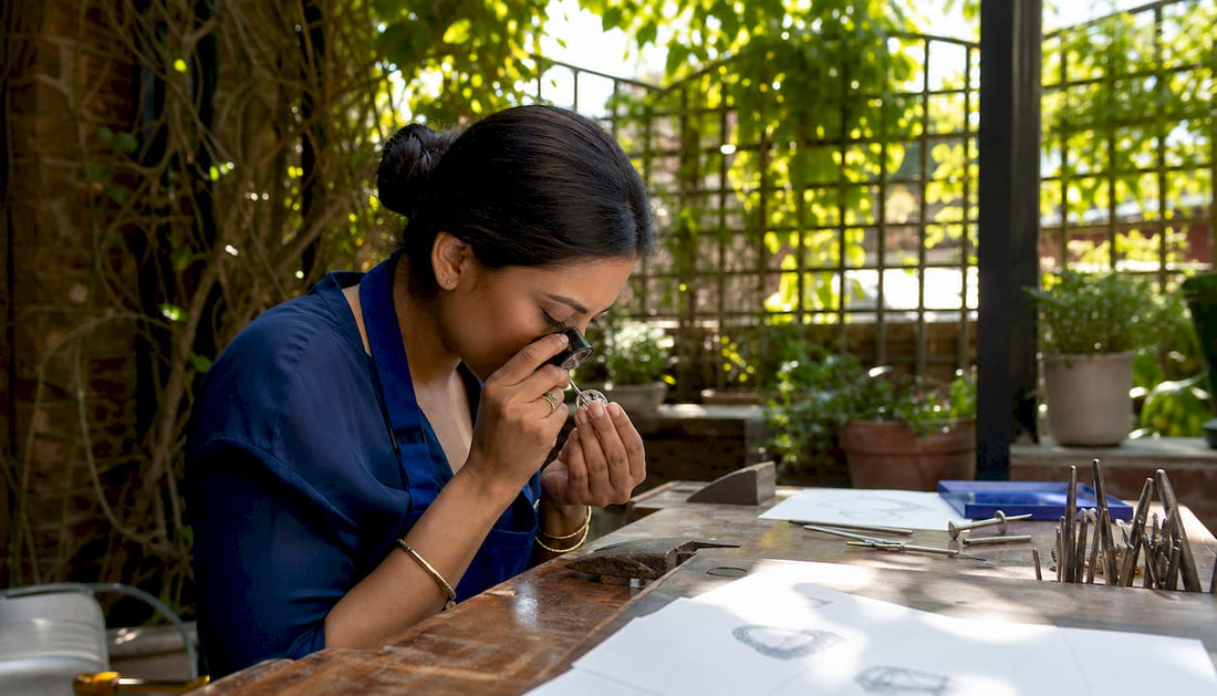 Jeweller examining bespoke ring prototype at workbench