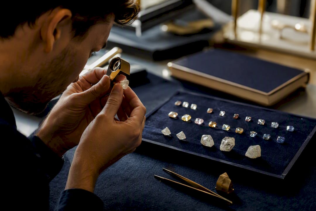 Jeweller inspecting diamond with loupe