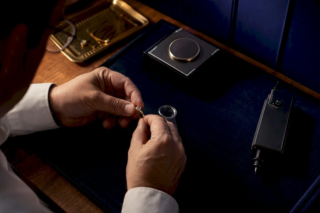 Jewellery valuer examining ring with testing tools