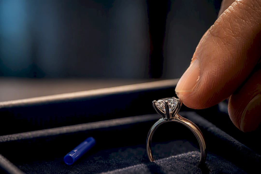 Fingertips checking a loose diamond setting