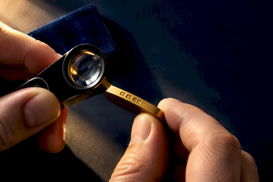 Jeweller inspecting gold hallmark marks
